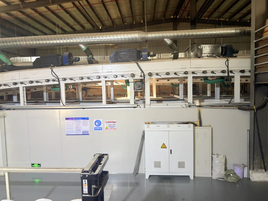 Wide view of the film plant floor with extraction ducting, the machine line and control cabinets