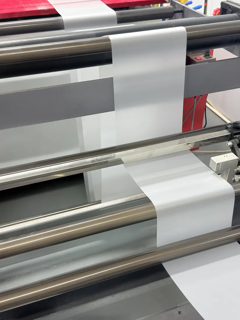 Film web passing through the rollers of a slitting machine