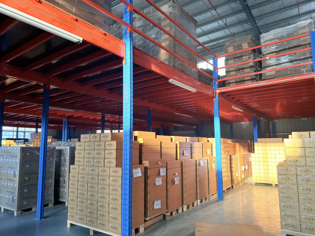 Wide aisle of a racked warehouse stacked with palletised boxed stock