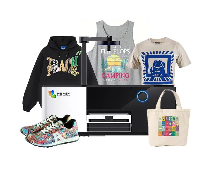 Impressora DTG HY-4050 exibida com peças de amostra impressas: moletom, colete, camiseta e sacola