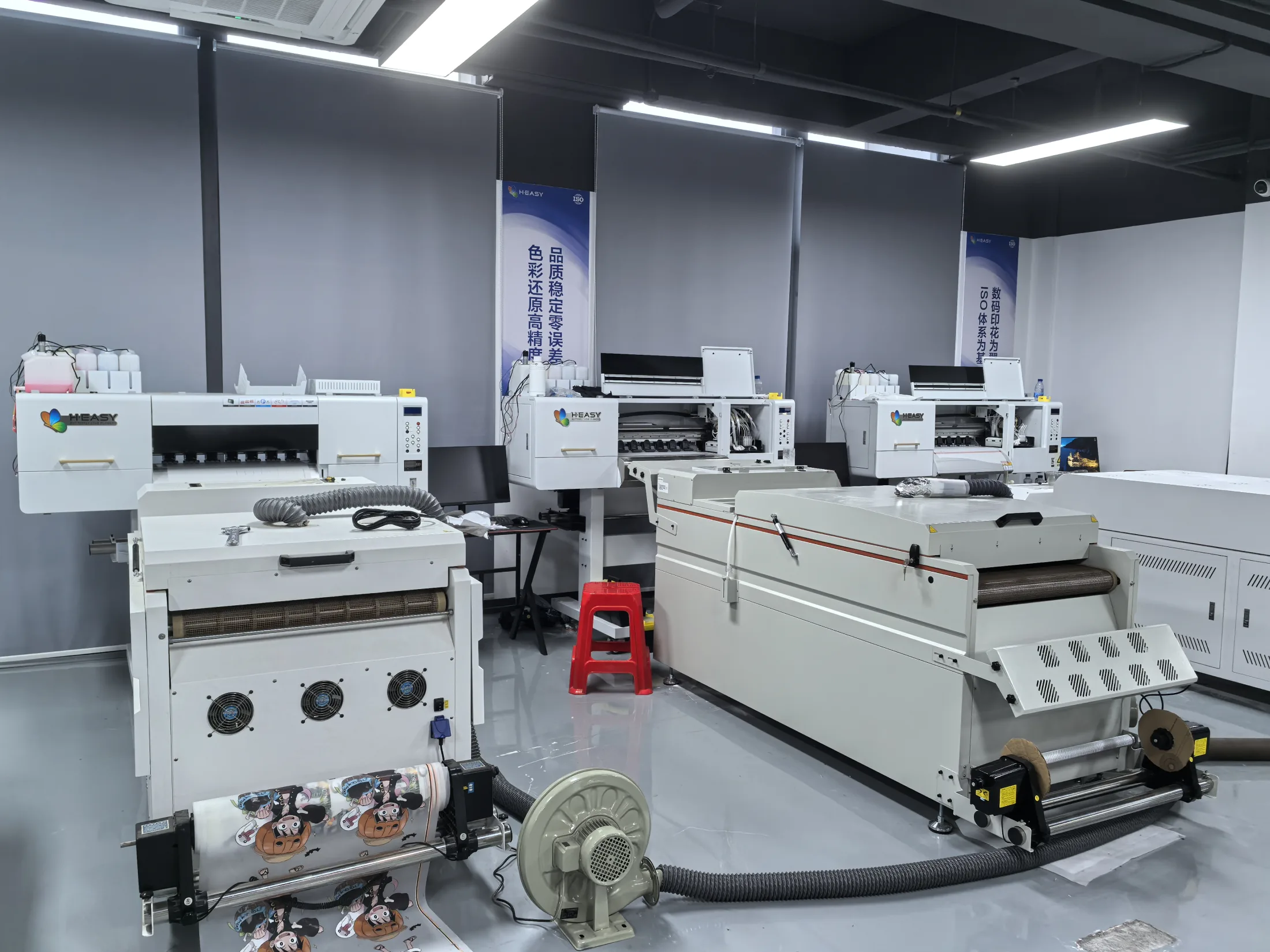 Textile production floor with printers, powder shaker and curing equipment arranged as a working line