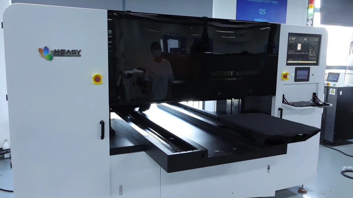 Blank dark garment entering the HY 2D DTG enclosure for the automatic in-line jetted pre-treatment stage