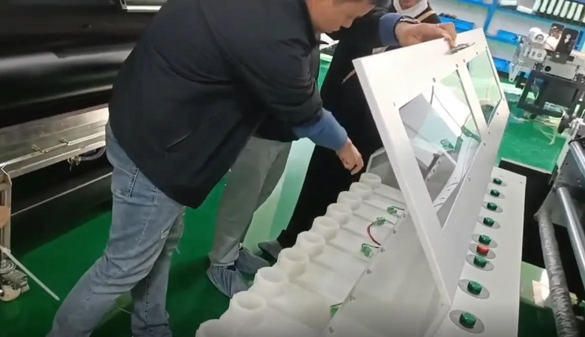 Visitor inspecting the textile printer's fabric-handling equipment