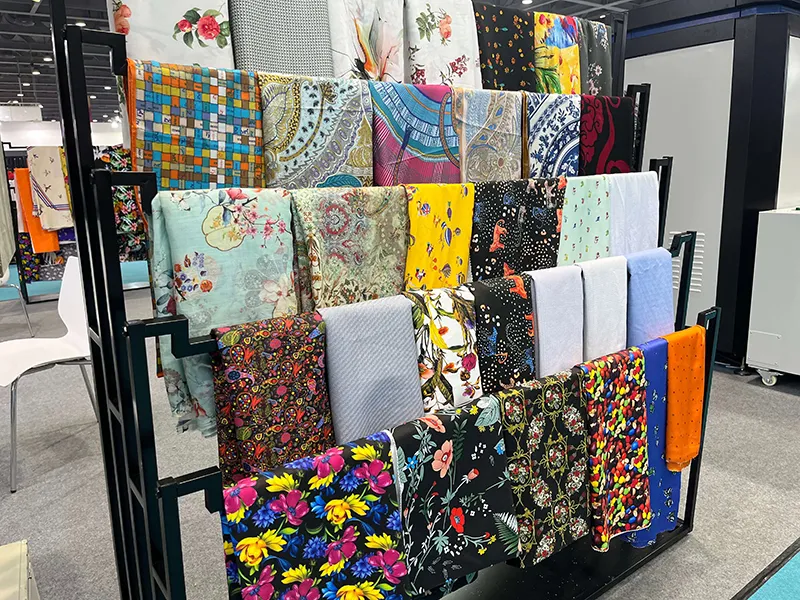 Colorful printed fabric samples displayed on racks for comparing textile applications