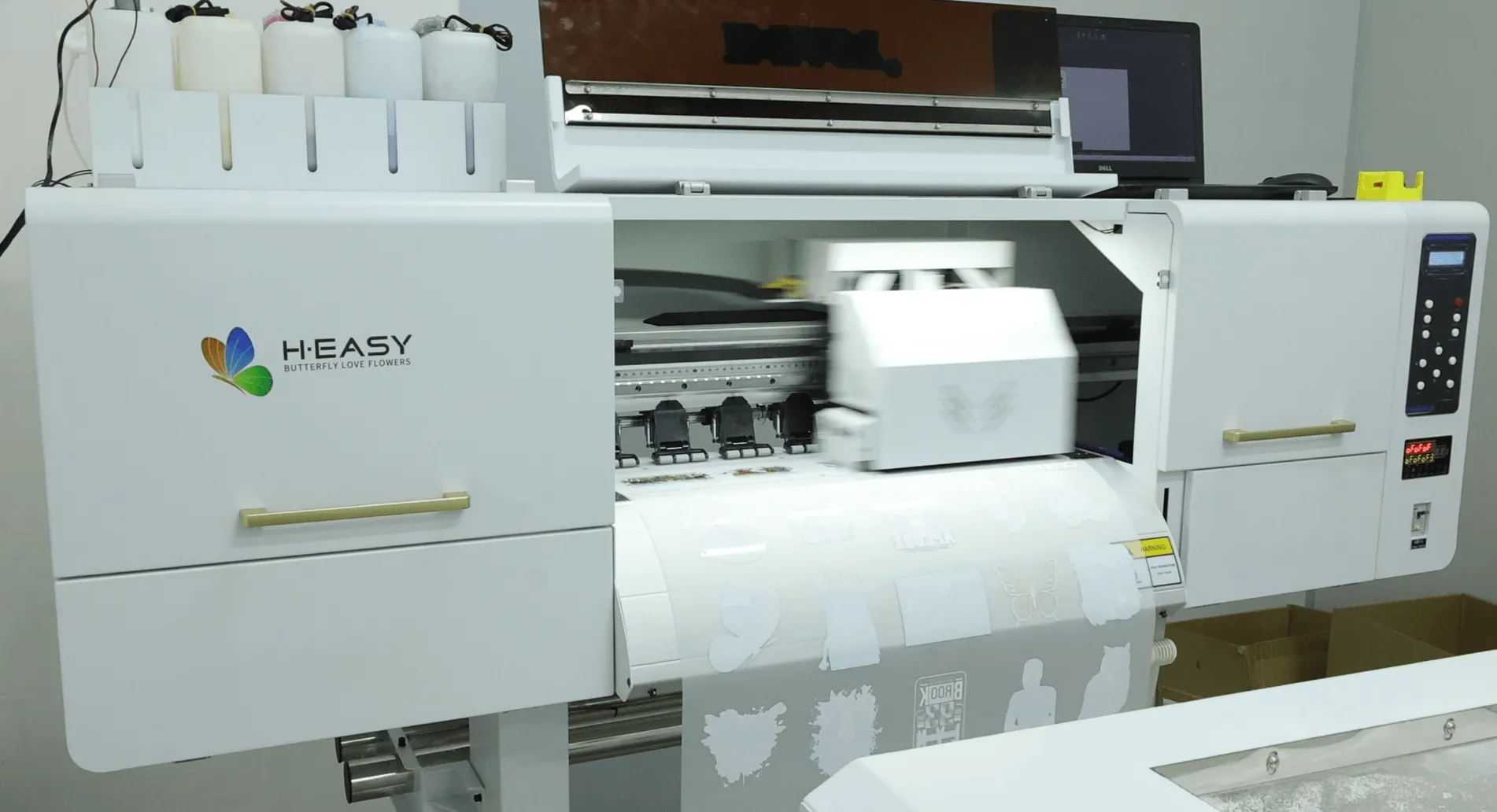 Enclosed DTF printer producing printed film for garment transfers