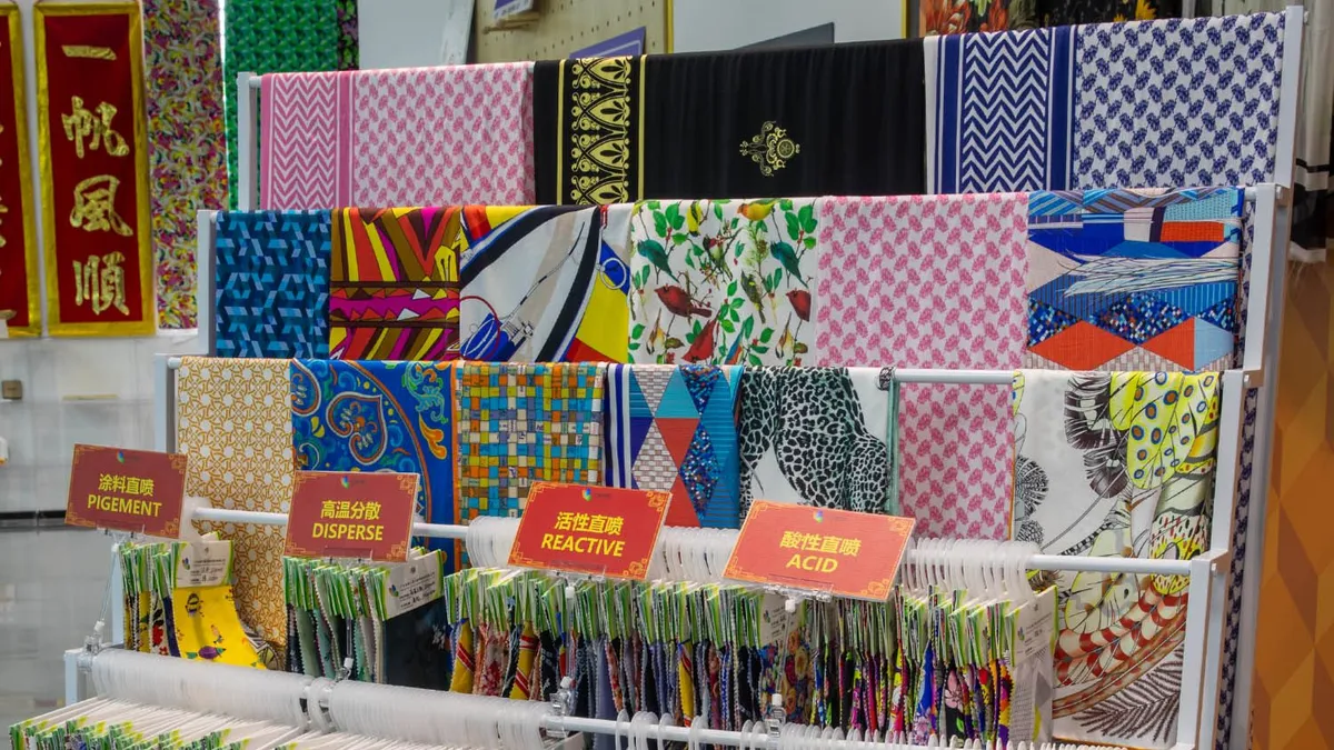Printed fabric coming off a roll-to-roll textile printer, showing even color across the width