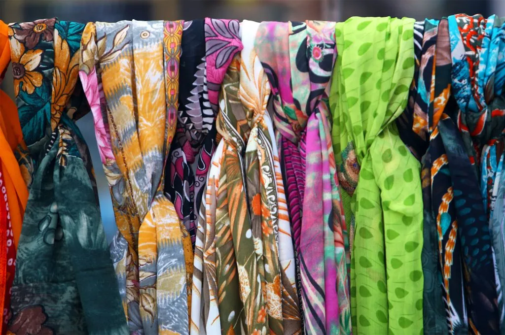 Lenços estampados coloridos com padrões florais, geométricos e abstratos expostos lado a lado
