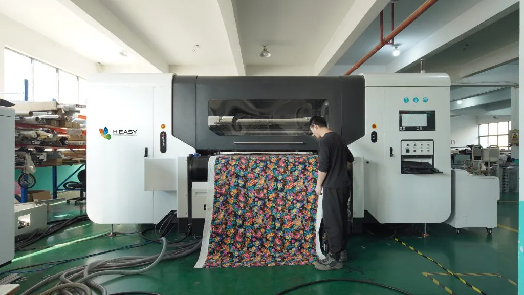 Operario inspeccionando tela floral en el lado de recogida de una impresora textil de rollo a rollo