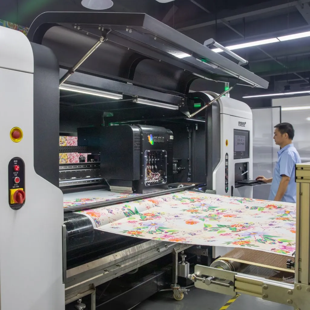 Operario vigilando el tejido floral mientras pasa por una impresora textil digital industrial