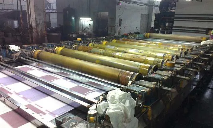 Pantallas rotativas colocadas sobre tejido estampado en una línea textil industrial