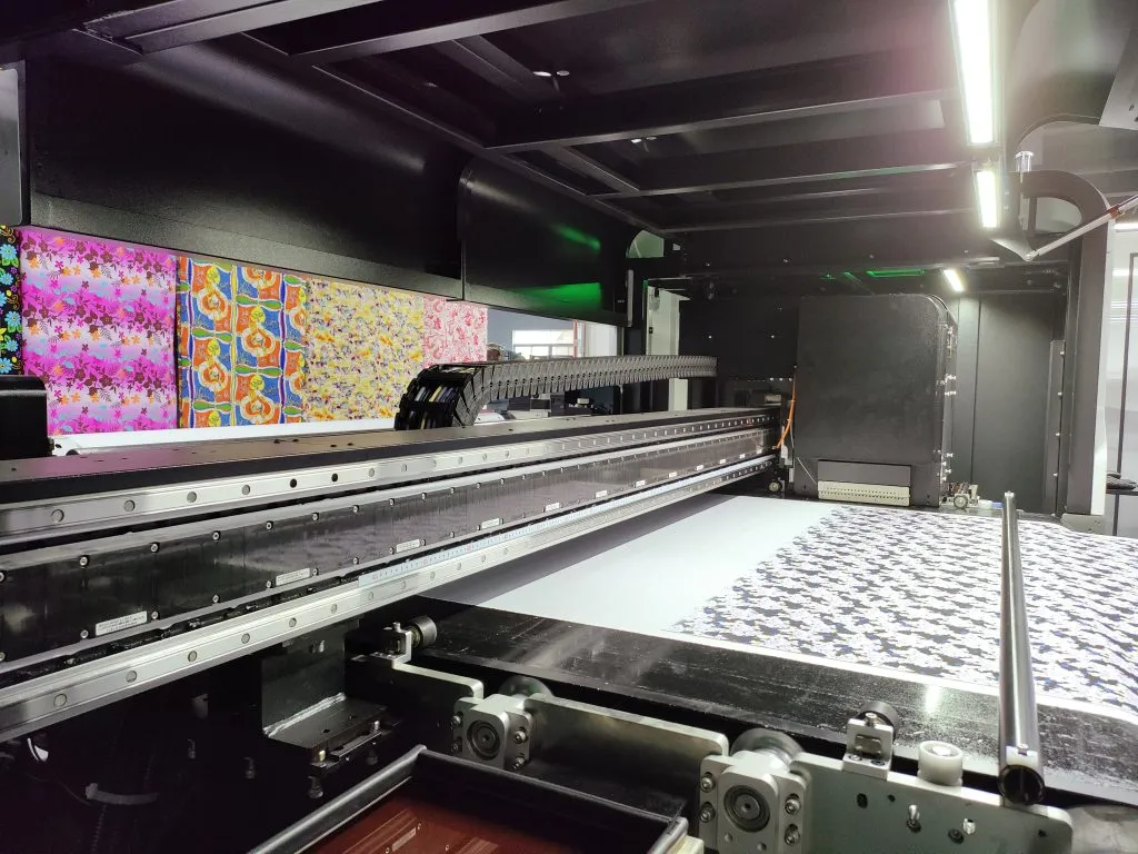 Impresora textil de gran formato aplicando un motivo repetido directamente sobre tejido blanco