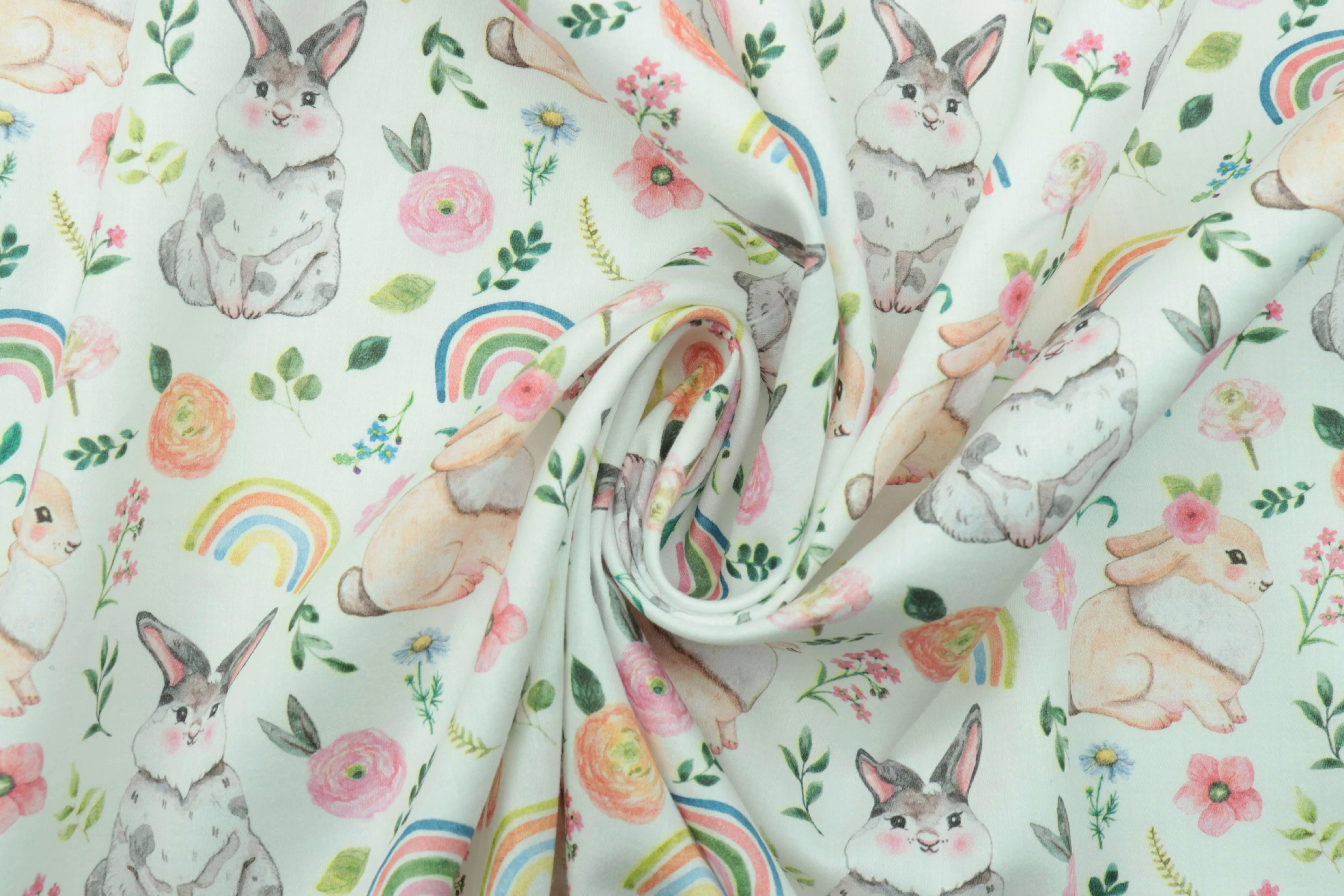 Soft baby textile fabric printed with rabbits, flowers, leaves, and rainbow motifs
