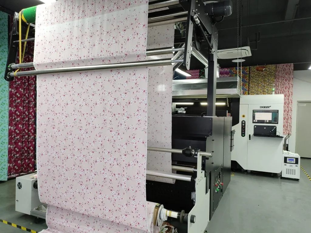 Tejido floral rosa pasando por la sección de recogida de una impresora textil de bobina a bobina