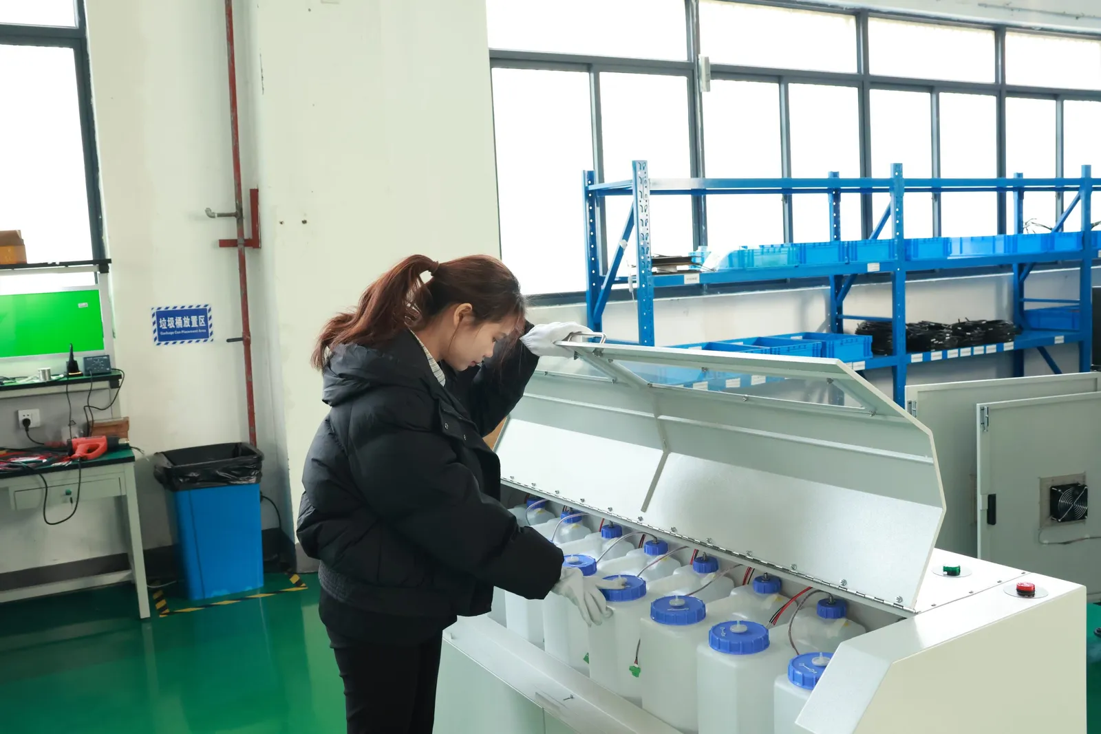 Técnico inspeccionando envases de tinta tapados dentro de una zona de fabricación de impresoras textiles