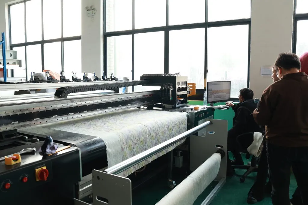 Operarios vigilando tejido estampado en una impresora textil de bobina a bobina de gran formato